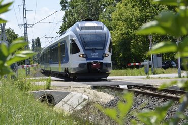 Székesfehérvár-Balatonfüred személyvonat halad egy Balatonfűzfői, fény- és félsorompóval biztosított vasúti átjáróban. - Fotó: Juhász Péter/Totalcar
