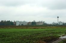 Az egyik lakótelep látképe a reptér széli dűlőútról, víztoronnyal