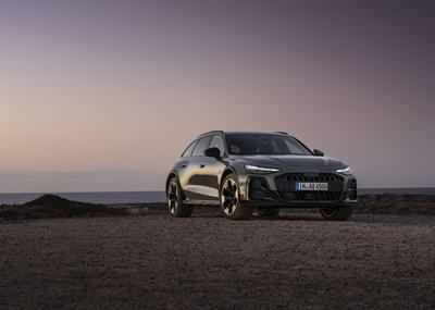 ¾ Front view of the Audi A6 allroad (pearl grey) against a calm sea horizon at dusk.