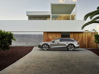 Side view of Audi A6 allroad (pearl grey) in front of modern architecture (static shot)