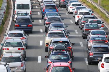 Rear view of traffic jam of lined up cars stuck on the highway toll.