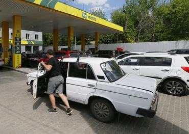 A driver pushes his car to a petrol station trying to buy fuel in Odesa, Ukraine 18 May 2022. Private public transport companies of Odesa have reduced the number of exits of their buses on routes due to lack of gasoline, according to local media. The operational headquarters under the Cabinet of Ministers decided to abandon state regulation of fuel prices, media reported on 17 May, referring to the Minister of Economy. Long queues have formed for petrol stations in Ukraine, as the country have fuel shortages, amid Russian invasion in Ukraine. (Photo by STR/NurPhoto via Getty Images)