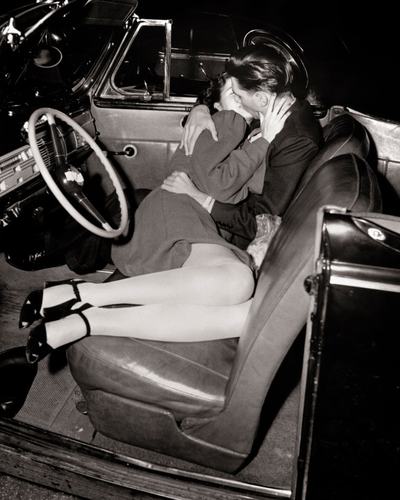 1940s Close-Up Of Passionate Hugging  Kissing Couple Man Woman Lying In Front Seat Of Convertible Car At Outdoor Drive-In Movie   (Photo by American Stock/Getty Images)