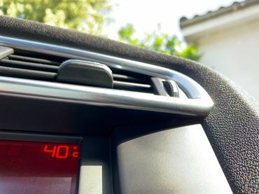 Vehicle parked in direct sunlight with a dashboard indicating a scorching temperature of 40 degrees celsius (104 Fahrenheit)