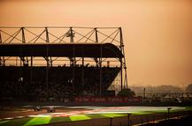 Brazilian Scuderia Ferrari Formula One team racing driver Felipe Massa driving his F138 racing car around Turn One of the circuit ahead of Finnish Williams racing driver Valtteri Bottas in his FW35 car while being watched by hundreds of fans and spectators sitting and standing in the start and finish straight Turn One grandstand,  alongside Airtel advertising signs and hoardings during the 2013 Indian Grand Prix, Buddh International Circuit, Greater Noida, India, on the 27th October 2013. (Photo by Darren Heath/Getty Images), (Editor's Note: Image has been digitally enhanced.)