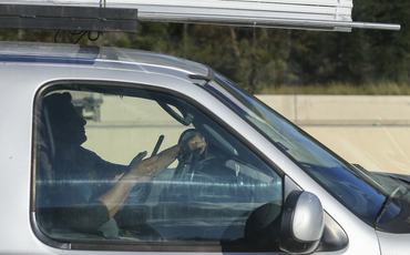 A motorist uses a cell phone while driving on the 610 West Loop Monday, Oct. 29, 2018, in Houston. (Photo by Godofredo A. Vasquez/Houston Chronicle via Getty Images)