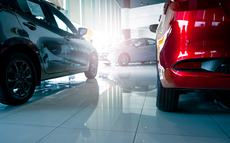 A stylish electric car parked inside a luxury dealership office where customers browse and rent automobiles in a modern showroom showcasing clean energy technology and urban transportation innovation.