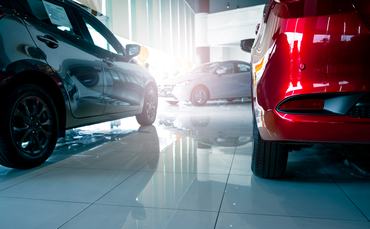 A stylish electric car parked inside a luxury dealership office where customers browse and rent automobiles in a modern showroom showcasing clean energy technology and urban transportation innovation.