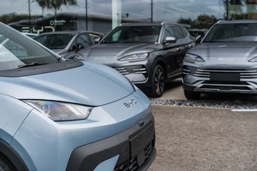 Crewe, Cheshire, England, August 30th 2025. A pale blue BYD Dolphin is parked at the dealership forecourt, with cars in the background.