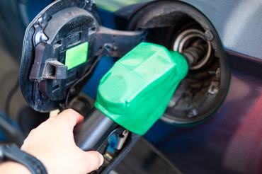 Cropped hand of man refueling car on gas station.