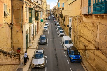 Sliema, Malta - October 23, 2025: Top view of a quiet European street with parked cars and traditional Maltese architecture on a sunny day.