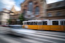Yellow City Tram Rushes In Motion On A Blurred Budapest Street