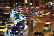 city streets and road traffic in Budapest, Hungary, at night. Street lights and random people