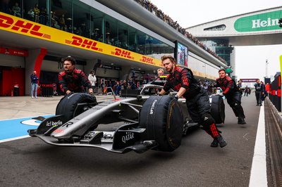 SHANGHAI, CHINA - MARCH 15: The R26 of Gabriel Bortoleto of Brazil and Audi Revolut F1 Team is wheeled in the pit lane by crew during the F1 Grand Prix of China at Shanghai International Circuit on March 15, 2026 in Shanghai, China. (Photo by Jayce Illman/Getty Images)