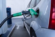 Close-up of a fuel nozzle inserted into a vehicle's tank. Concept of transportation, energy consumption, and daily routine.