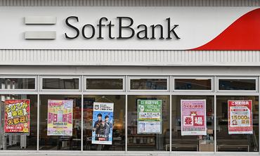 KUDAMATSU, JAPAN - APRIL 14: The storefront of a SoftBank retail branch, showcasing current mobile and internet service promotions, is pictured in Kudamatsu, Yamaguchi Prefecture, Japan, on April 14, 2026. As a leading telecommunications company, SoftBank offers various consumer services including SoftBank Air home internet and Y!mobile family discount plans, frequently advertised through colorful window posters. (Photo by STR/NurPhoto via Getty Images)