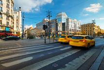 Budapest, Hungary - November 9, 2025: Two yellow taxis driving fast on a city street in Budapest during a bright autumn day.