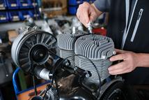 27 April 2026, Saxony, Zwickau: Frank Hofmann, head of Trabantwelt Zwickau, screws a spark plug into the cylinder head of a two-stroke engine for a Trabant 601 in the spare parts dealer's workshop. The company has been one of the larger suppliers of Trabi spare parts for 23 years. Some of these still come from original stocks, but the production of new parts plays a greater role, says the managing director. Tens of thousands of vintage GDR cars such as the Trabant, whose production ended on April 30, 1991, are still on the road, and registration figures have recently risen again. Photo: Jan Woitas/dpa (Photo by Jan Woitas/picture alliance via Getty Images)