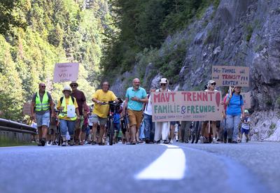27 June 2026, Austria, Reutte: Protesters carrying a sign that reads, "Tolls divide families and friendsvisits must not become a luxury!" are marching in a demonstration along the closed B179 Fernpass Road toward a rally. Photo: Karl-Josef Hildenbrand/dpa (Photo by Karl-Josef Hildenbrand/picture alliance via Getty Images)