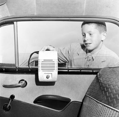 circa 1955:  A young worshipper at a Protestant Council's Drive-In Church service at Bronx Whitestone Drive-In theatre, sets up his individual speaker in the family car.  (Photo by Orlando /Three Lions/Getty Images)